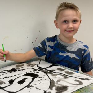 Homeschool art creates portrait with ink.